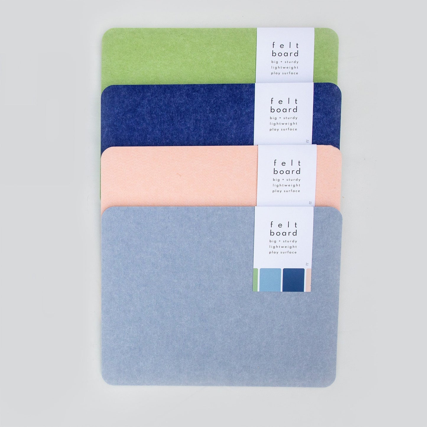 set of four colorful felt boards for building block toy play surfaces in green, blue, peach, and gray colors