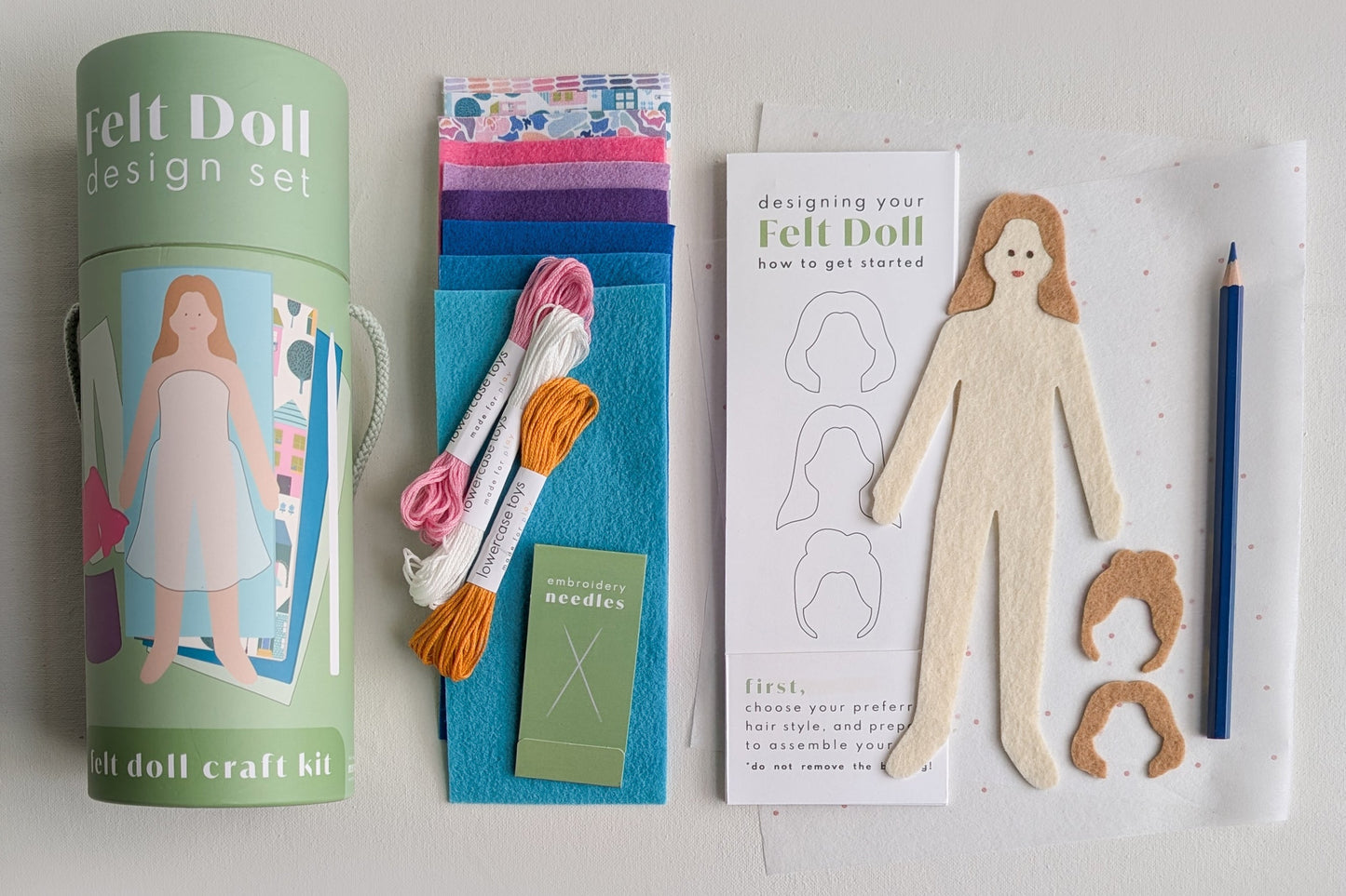 Felt doll design set with materials and instructions on a light gray background