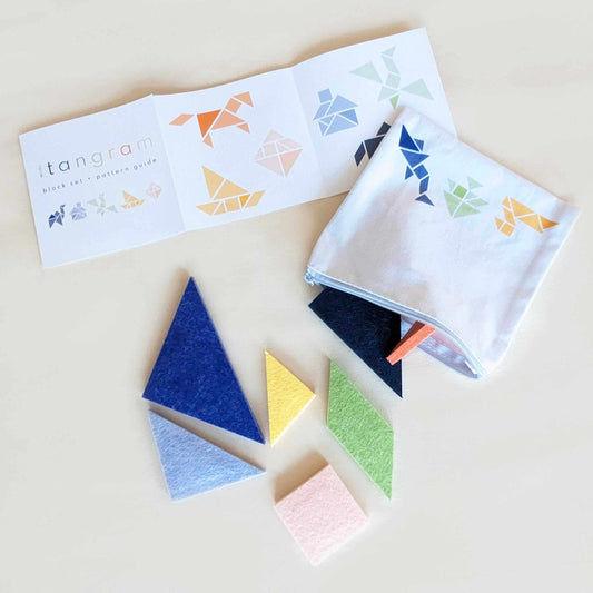 tangram shapes spill out of a zipper pouch, felt tangram pieces are made from recycled water bottles to be durable and washable